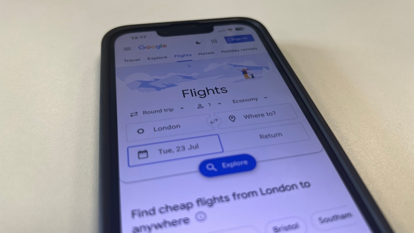 Image of a mobile phone and google being used to book a flight 