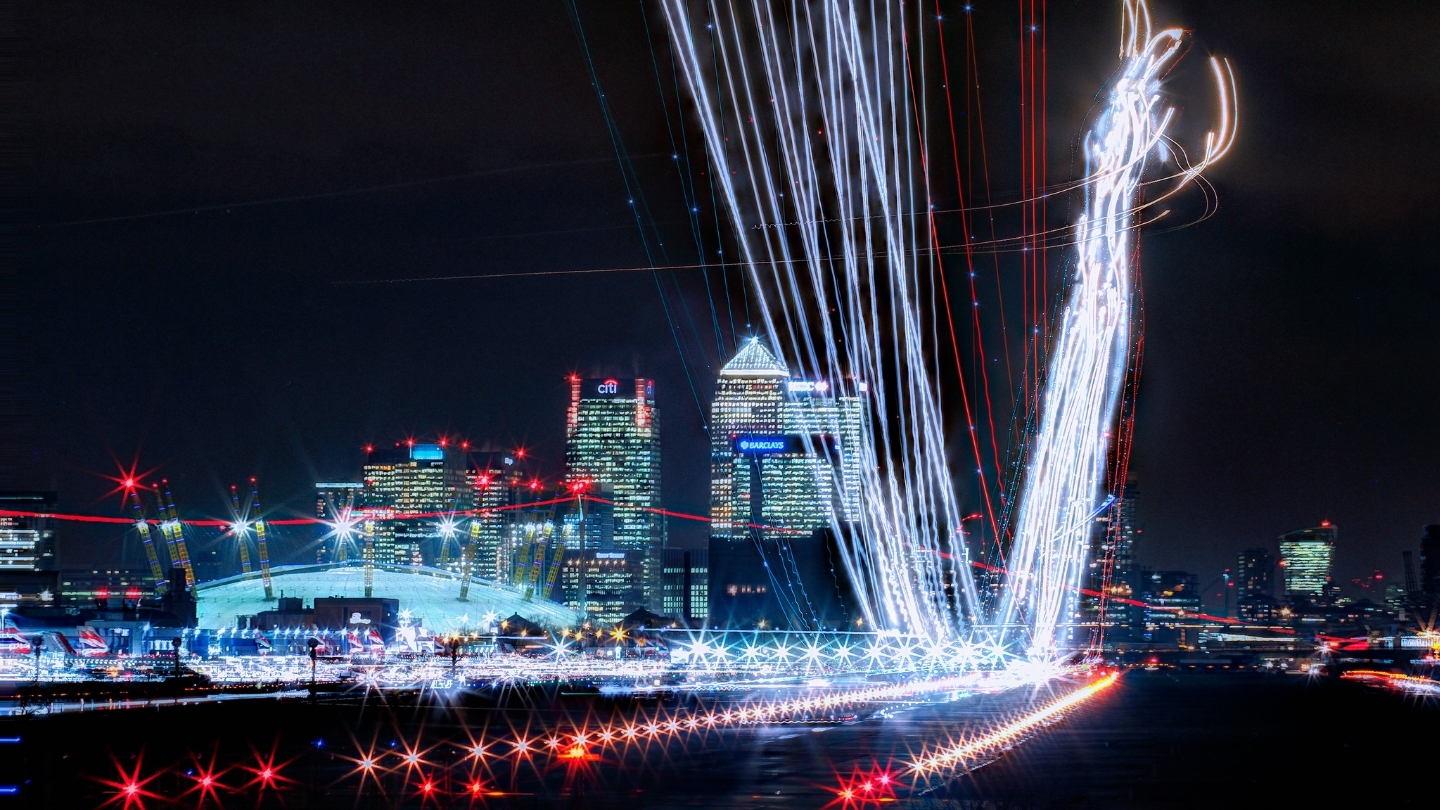 An image taken at London City Airport at night time with a light trail effect added