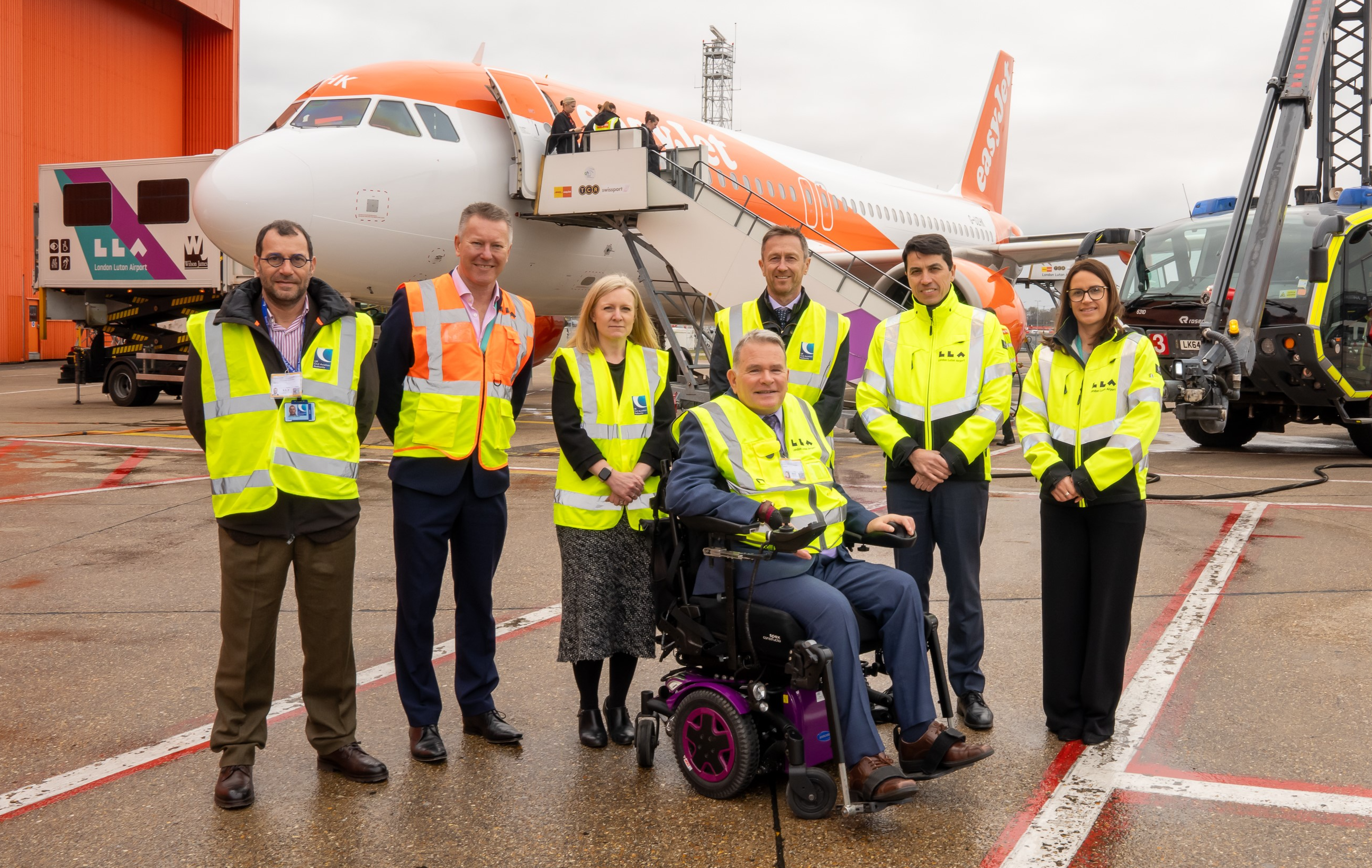 People standing in front of an aircraft and a fire engine